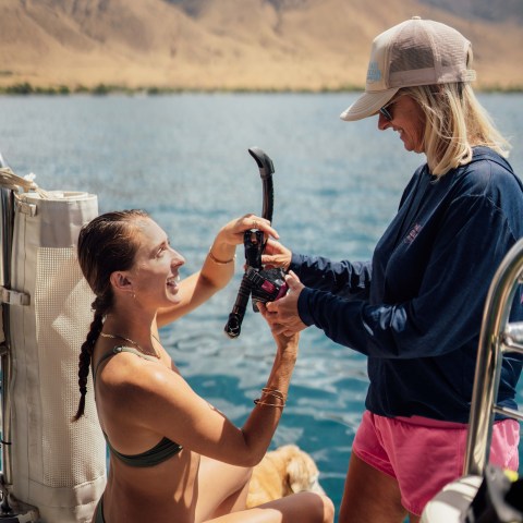 a woman helping with snorkel gear